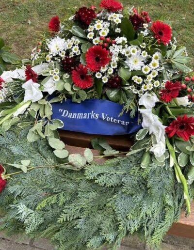 Veteranenwochenende 2024 mit dem 8.Tag der EinsatzVeteranen 73 Blumenkranz mit Rotweißen Blumen mit Aufschrift Danmarks Veteranen