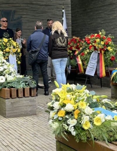 Veteranenwochenende 2024 mit dem 8.Tag der EinsatzVeteranen 42 Menschen an Gedenkstätte mit Blumenkränzen